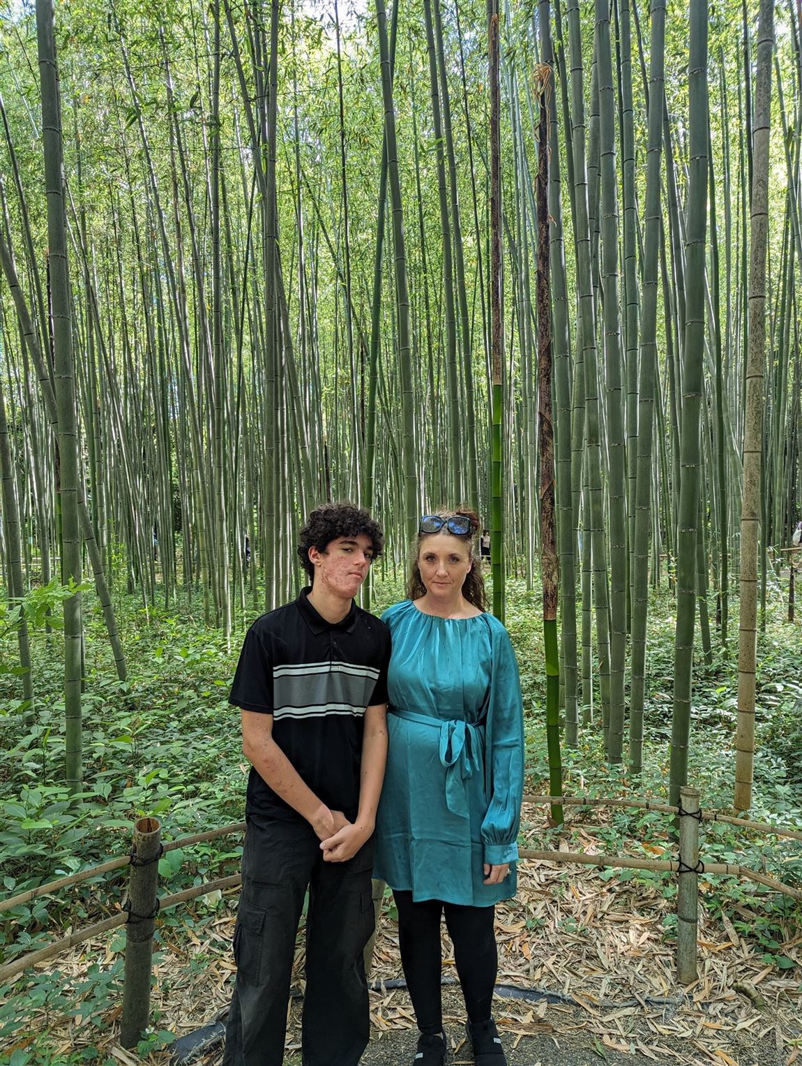 Jillian and Tom standing in a towering bamboo forest in Japan