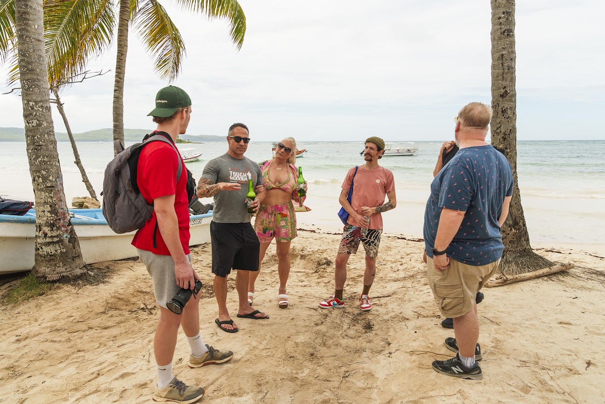 A small group on a Caribbean beach in the Dominican Republic, turquoise water and palm trees behind them