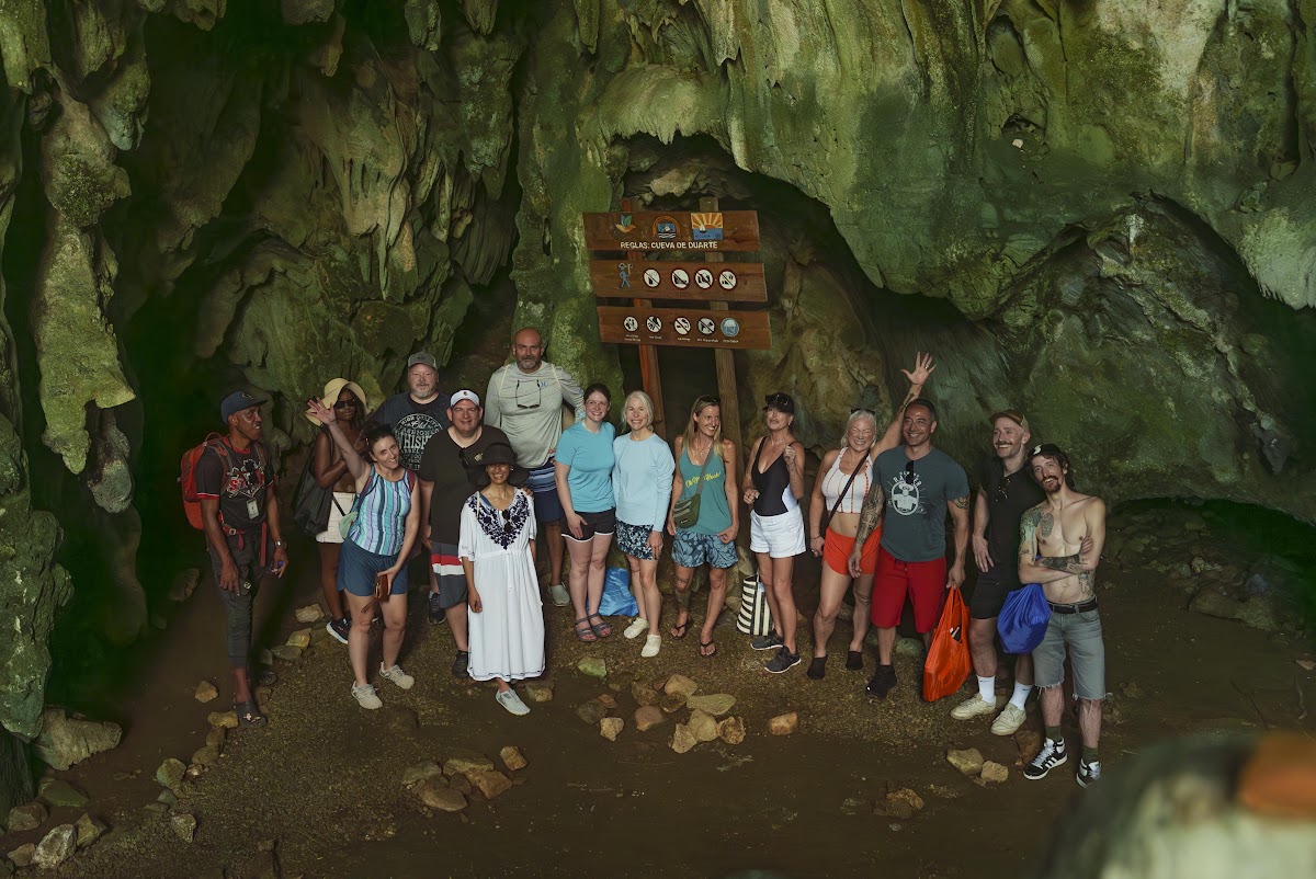 The group gathered at the mouth of a cave on the hike