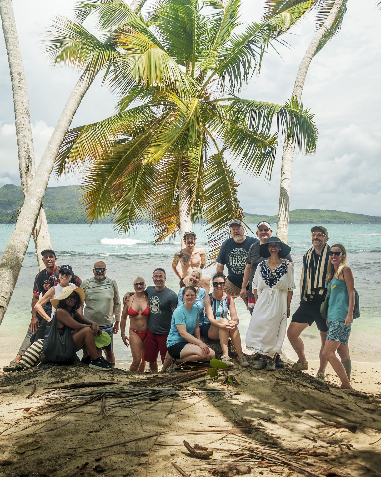 The whole Last Life Ever group under the palms on a Samaná beach