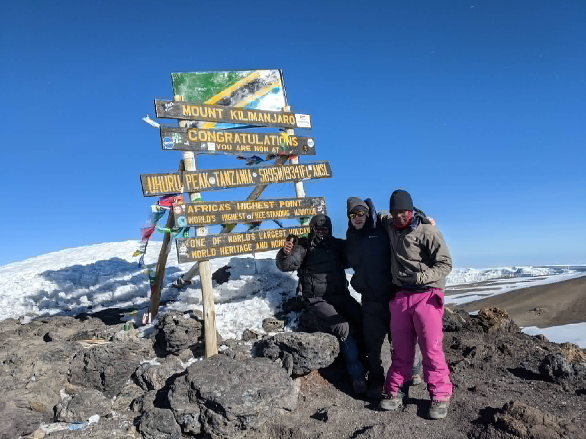 Jeff at the Uhuru Peak sign on the summit of Kilimanjaro, glaciers behind